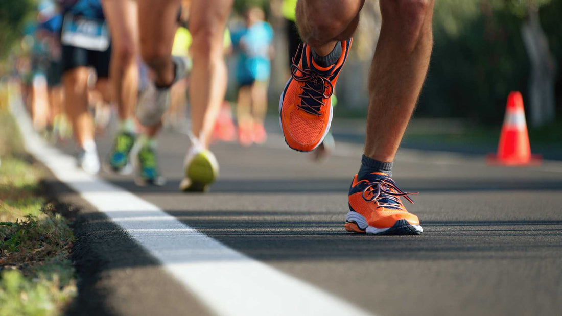 Dettaglio delle scarpe di atleti in corsa su strada, a rappresentare la performance sportiva e l'energia a lungo rilascio supportate dall'Olio di Frantoio D'Orazio.